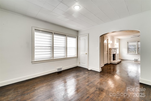 unfurnished room featuring a fireplace, ornamental molding, and dark hardwood / wood-style floors