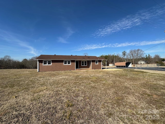 rear view of property featuring a lawn