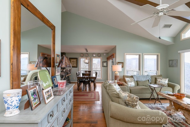 living room with dark wood-type flooring, ceiling fan, and high vaulted ceiling