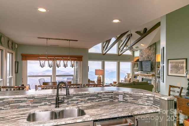 kitchen with sink, decorative light fixtures, vaulted ceiling, a mountain view, and dishwasher