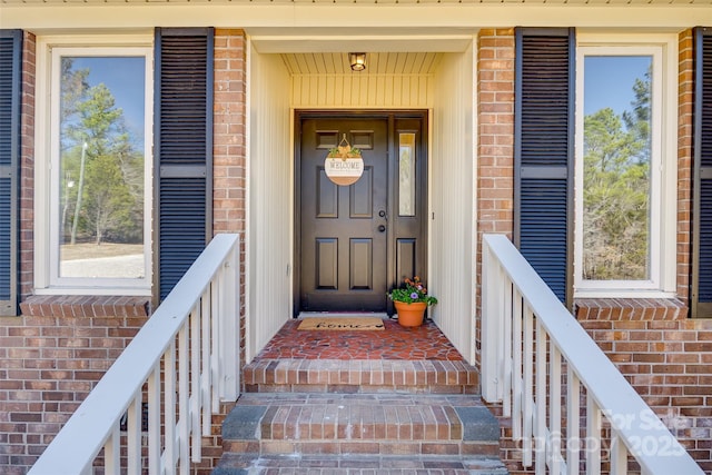 view of exterior entry with brick siding