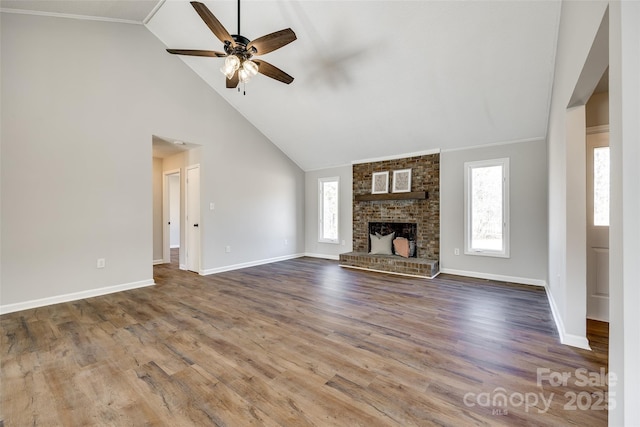 unfurnished living room featuring a fireplace, wood finished floors, a ceiling fan, and baseboards