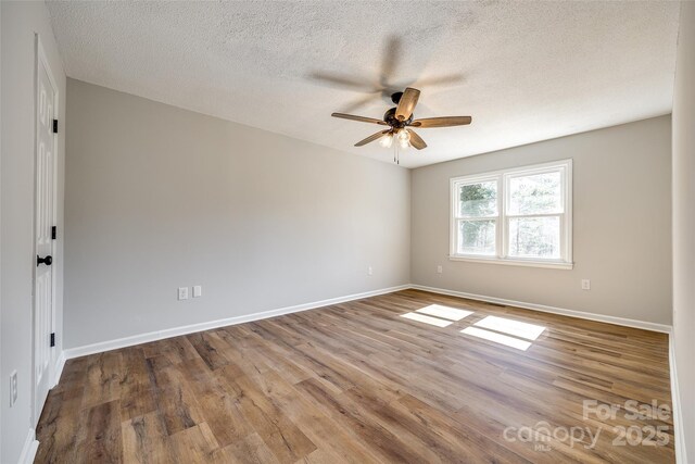 unfurnished room featuring ceiling fan, a textured ceiling, baseboards, and wood finished floors