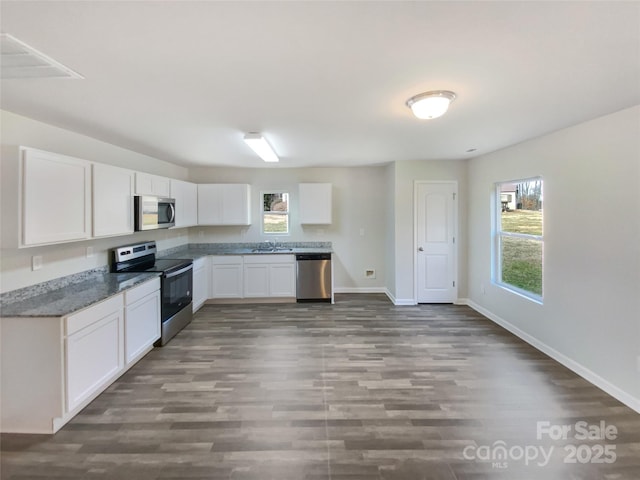 kitchen featuring dark wood-type flooring, stainless steel appliances, sink, and white cabinets