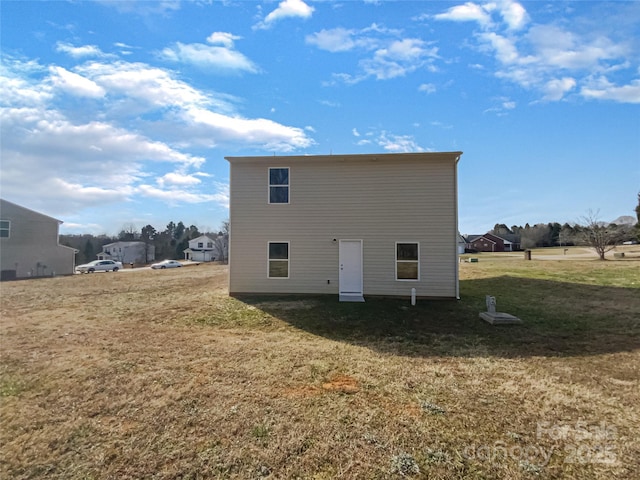 rear view of house featuring a lawn