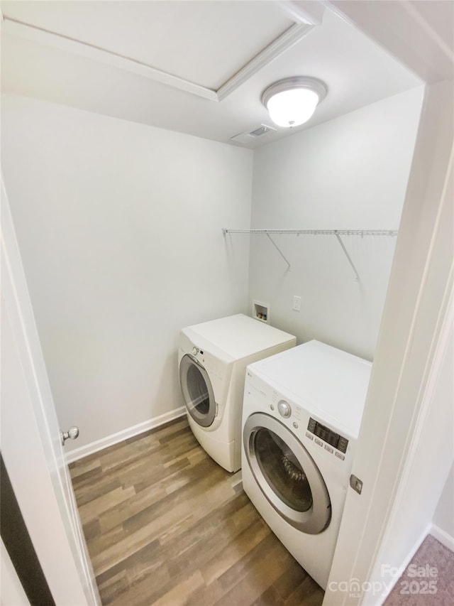 laundry room featuring washing machine and clothes dryer and hardwood / wood-style floors