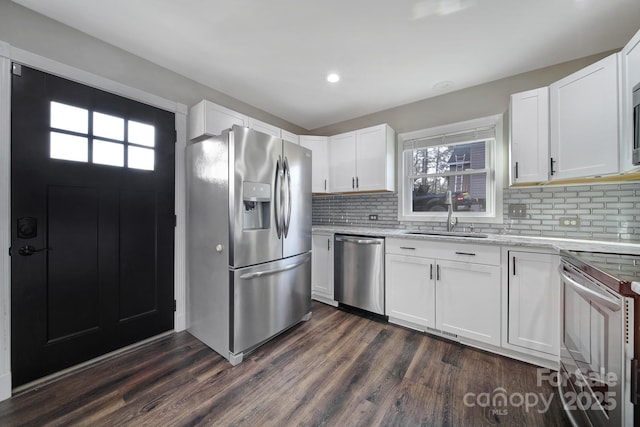 kitchen with stainless steel appliances, a sink, dark wood finished floors, and white cabinetry