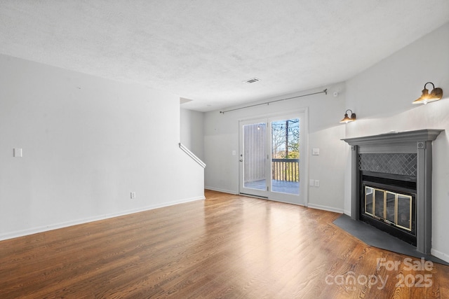 505 Victory Trl, Morganton, NC 28655 - unfurnished living room with a tiled fireplace, visible vents, baseboards, and wood finished floors