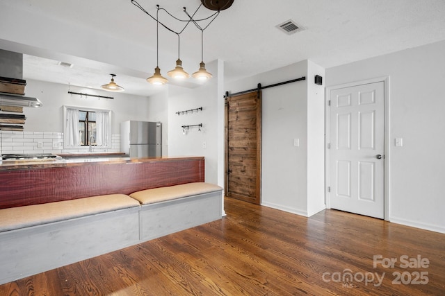 505 Victory Trl, Morganton, NC 28655 - kitchen with visible vents, a barn door, appliances with stainless steel finishes, wood finished floors, and backsplash