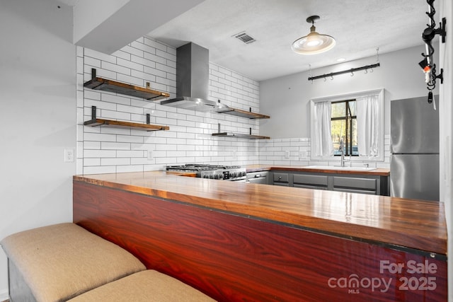 505 Victory Trl, Morganton, NC 28655 - kitchen with range, freestanding refrigerator, wall chimney range hood, open shelves, and visible vents