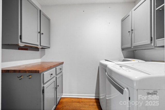 505 Victory Trl, Morganton, NC 28655 - laundry area featuring separate washer and dryer, baseboards, wood finished floors, and cabinet space