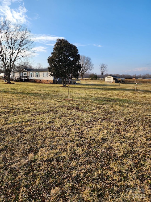 view of yard with a rural view and a storage unit