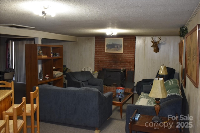 carpeted living room featuring a brick fireplace and a textured ceiling