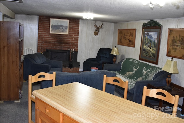 living room featuring a fireplace, carpet floors, and a textured ceiling