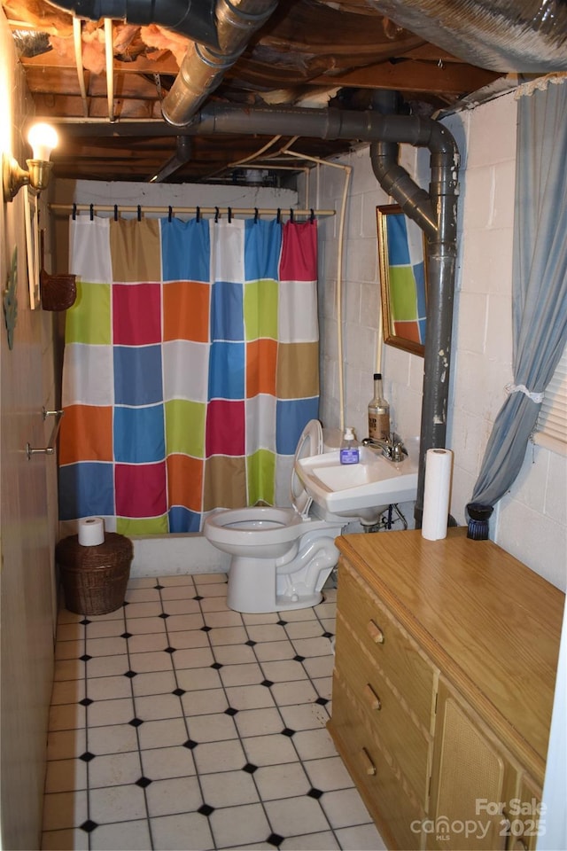 bathroom with sink, curtained shower, and toilet