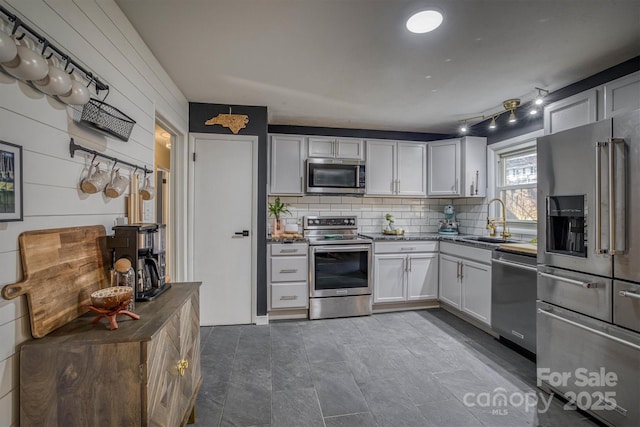 kitchen featuring sink, decorative backsplash, white cabinets, and appliances with stainless steel finishes