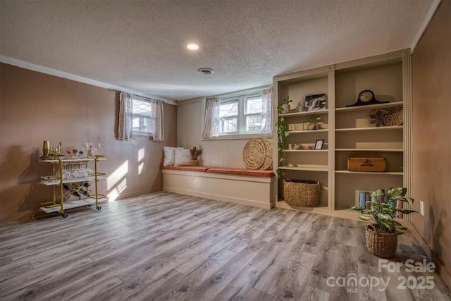 living area with wood-type flooring and a textured ceiling