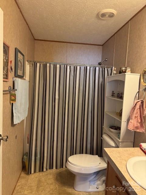 bathroom featuring vanity, a textured ceiling, curtained shower, and toilet