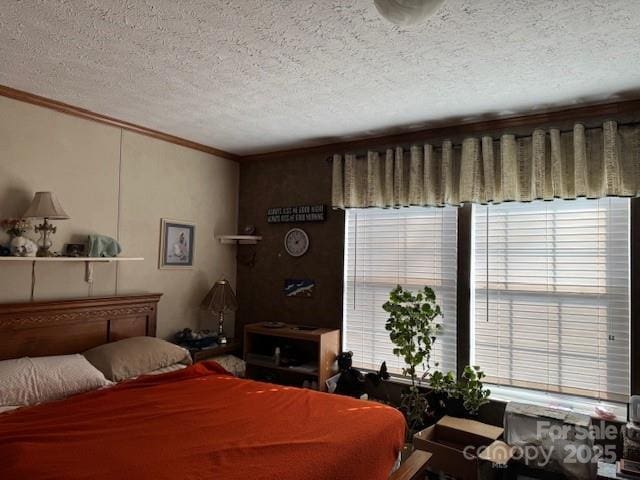 bedroom featuring ornamental molding and a textured ceiling