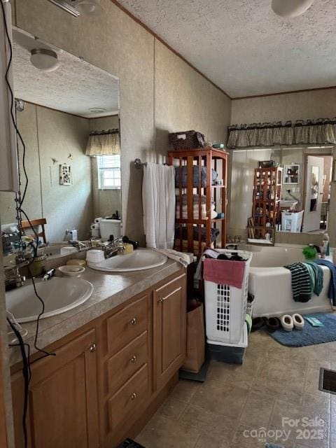 bathroom with a bathing tub, vanity, and a textured ceiling