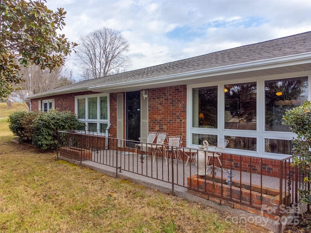 rear view of property featuring a lawn and a patio area