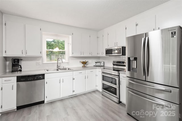 107 Deese Ct, Indian Trail, NC 28079 - kitchen with appliances with stainless steel finishes, a sink, white cabinetry, decorative backsplash, and a textured ceiling