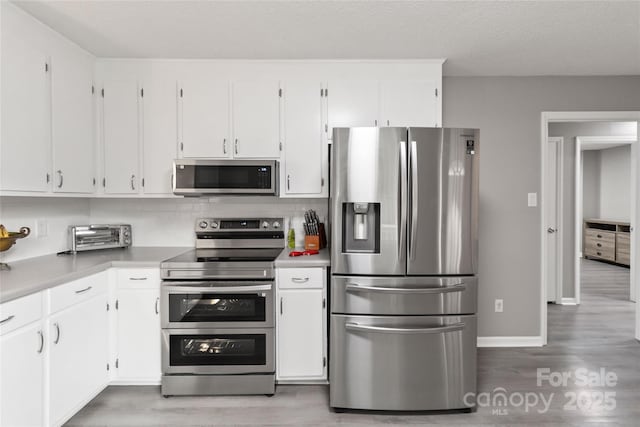 107 Deese Ct, Indian Trail, NC 28079 - kitchen with appliances with stainless steel finishes, wood finished floors, light countertops, and white cabinets