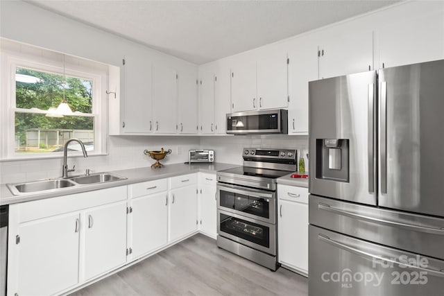 107 Deese Ct, Indian Trail, NC 28079 - kitchen featuring appliances with stainless steel finishes, a sink, tasteful backsplash, and white cabinets