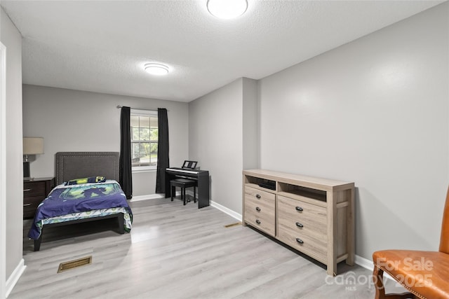 107 Deese Ct, Indian Trail, NC 28079 - bedroom with light wood-style floors, a textured ceiling, and baseboards