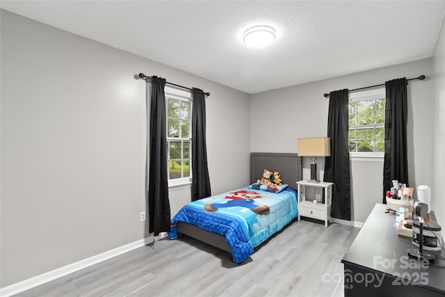 107 Deese Ct, Indian Trail, NC 28079 - bedroom with light wood-style floors, multiple windows, baseboards, and a textured ceiling