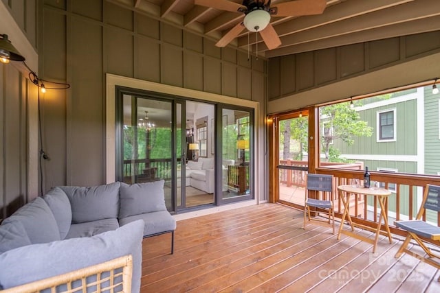 sunroom with beamed ceiling and ceiling fan