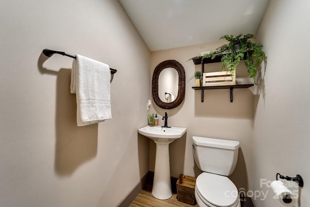 bathroom with wood-type flooring and toilet