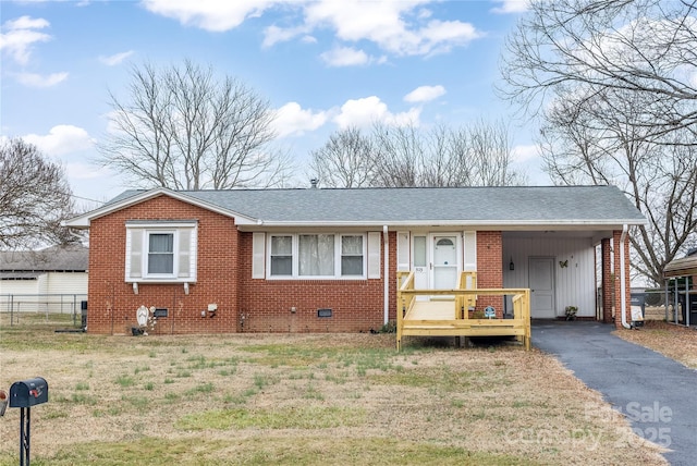 ranch-style home featuring a front lawn and a carport