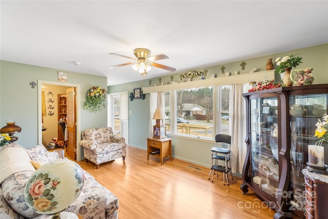 living area with ceiling fan and light wood-type flooring