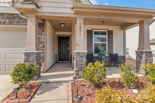 entrance to property with covered porch and a garage