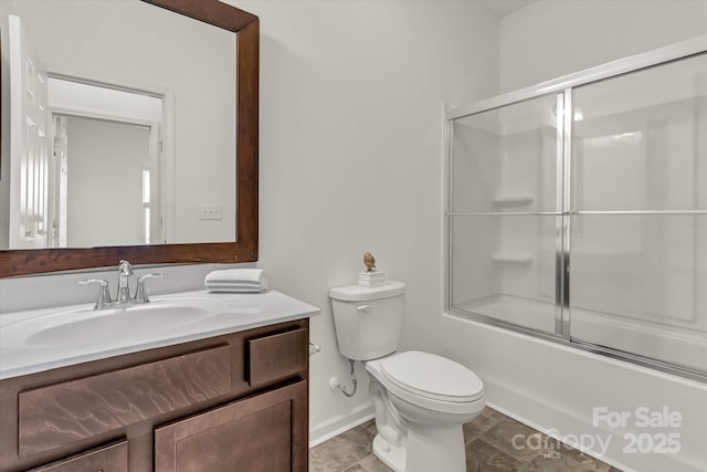 full bathroom featuring toilet, combined bath / shower with glass door, and vanity