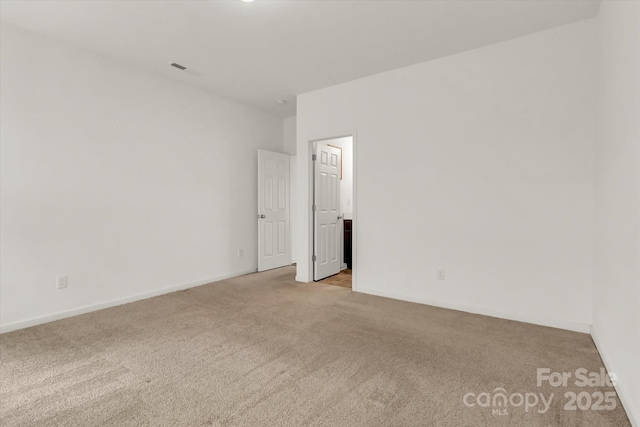 spare room featuring light colored carpet