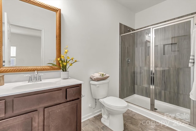 bathroom with toilet, vanity, and an enclosed shower