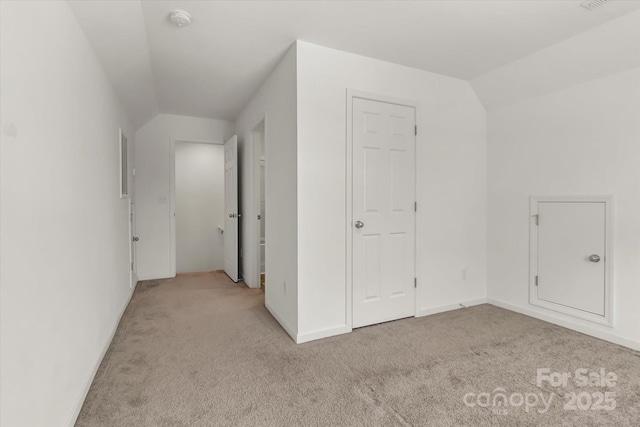 additional living space with vaulted ceiling and light colored carpet