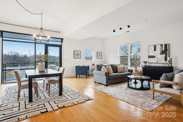 living room with a chandelier and light wood-type flooring