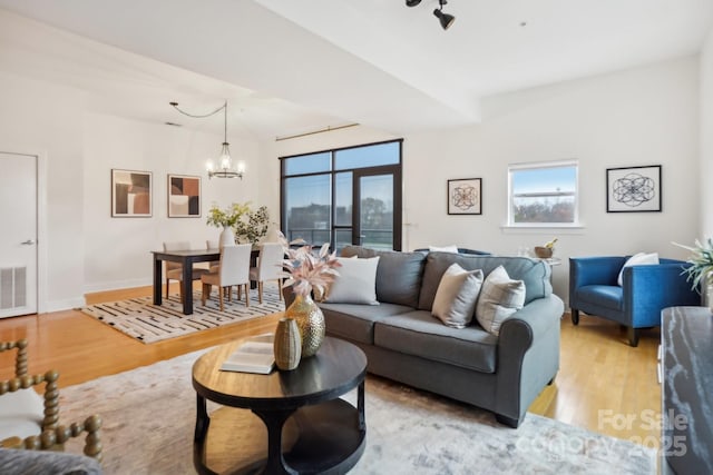 living room featuring an inviting chandelier and light wood-type flooring