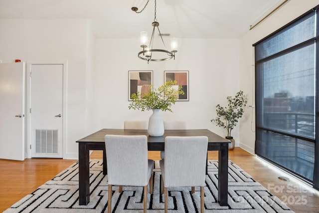 dining area featuring wood-type flooring and a chandelier