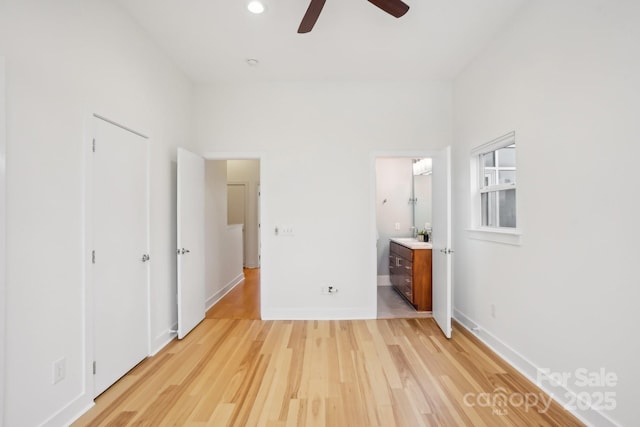 unfurnished bedroom featuring ensuite bathroom, sink, and light hardwood / wood-style flooring