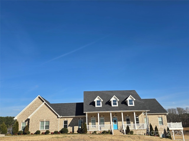 view of front of home with a porch and brick siding