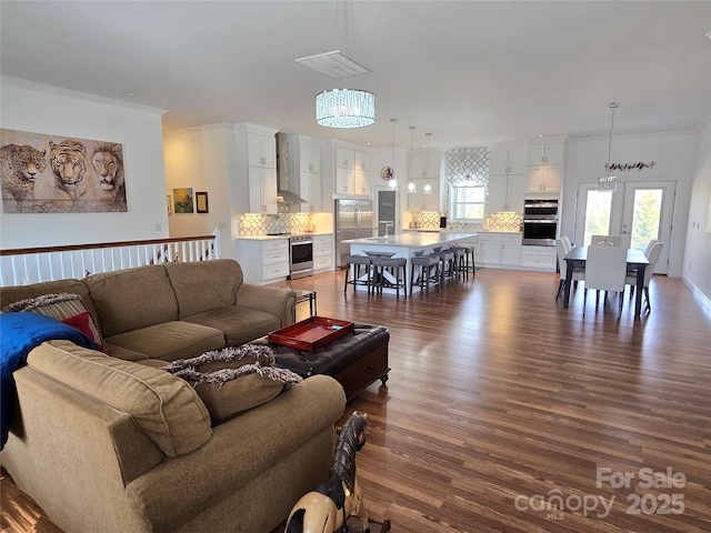 living room with visible vents, dark wood finished floors, and crown molding