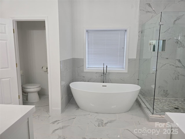 full bathroom featuring toilet, vanity, marble finish floor, a soaking tub, and a marble finish shower