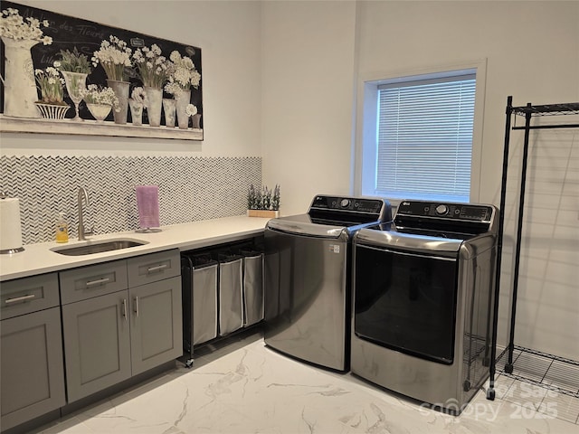 laundry area with marble finish floor, independent washer and dryer, a sink, and cabinet space