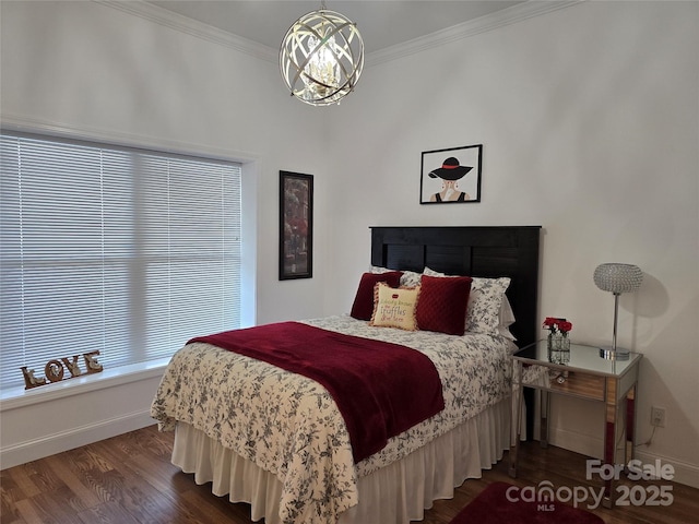 bedroom featuring baseboards, a notable chandelier, wood finished floors, and crown molding