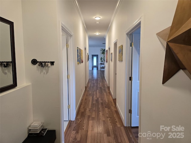 hall with baseboards, dark wood finished floors, and crown molding