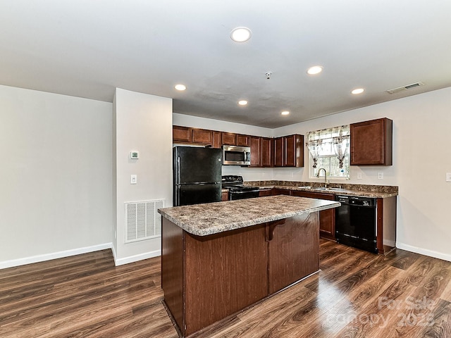 kitchen with dark wood-type flooring, sink, a kitchen island, and black appliances